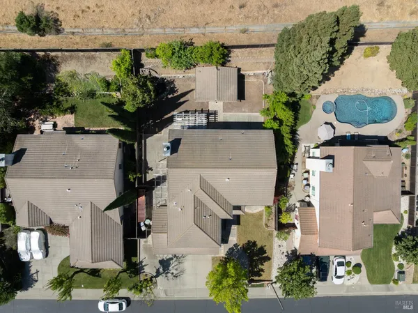 an aerial view of residential houses with outdoor space and ocean view