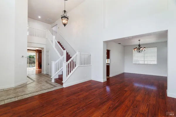 a view of a hallway with wooden floor and staircase
