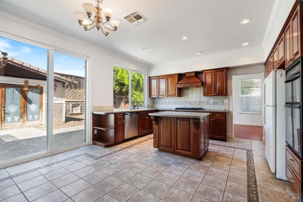 a kitchen with stainless steel appliances granite countertop a refrigerator and a stove