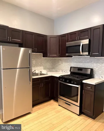 a white refrigerator freezer and a stove sitting inside of a kitchen with granite countertop stainless steel appliances