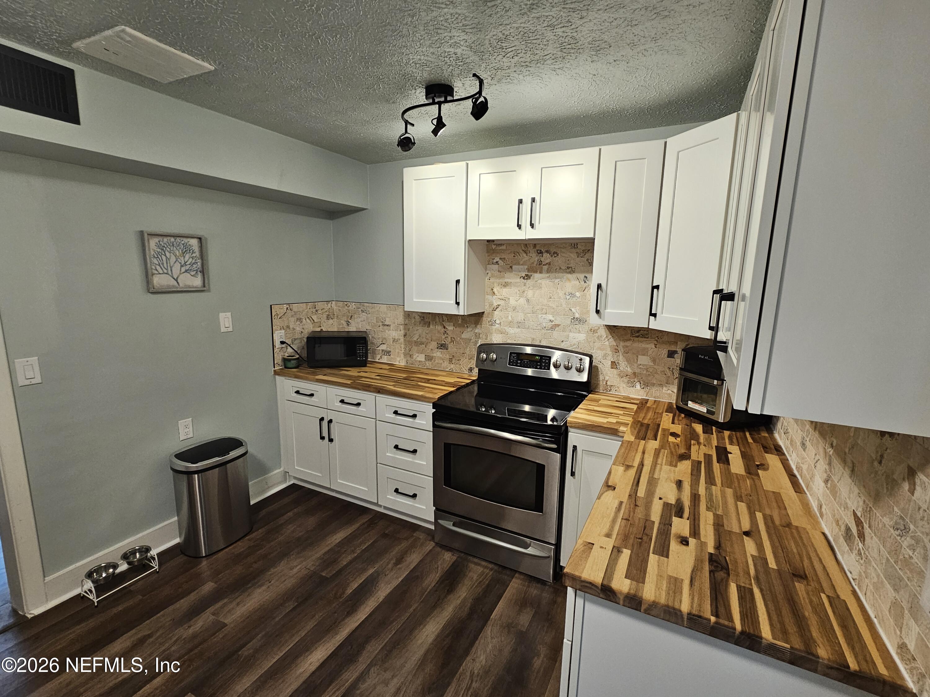 7269 Balboa Road Jacksonville, FL 32217 - Photo 7 of 24 a kitchen with a stove and a white wooden cabinets