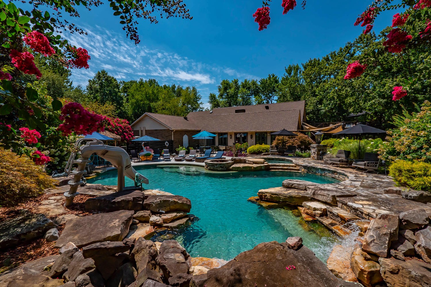 a view of a swimming pool and lounge chairs in back yard