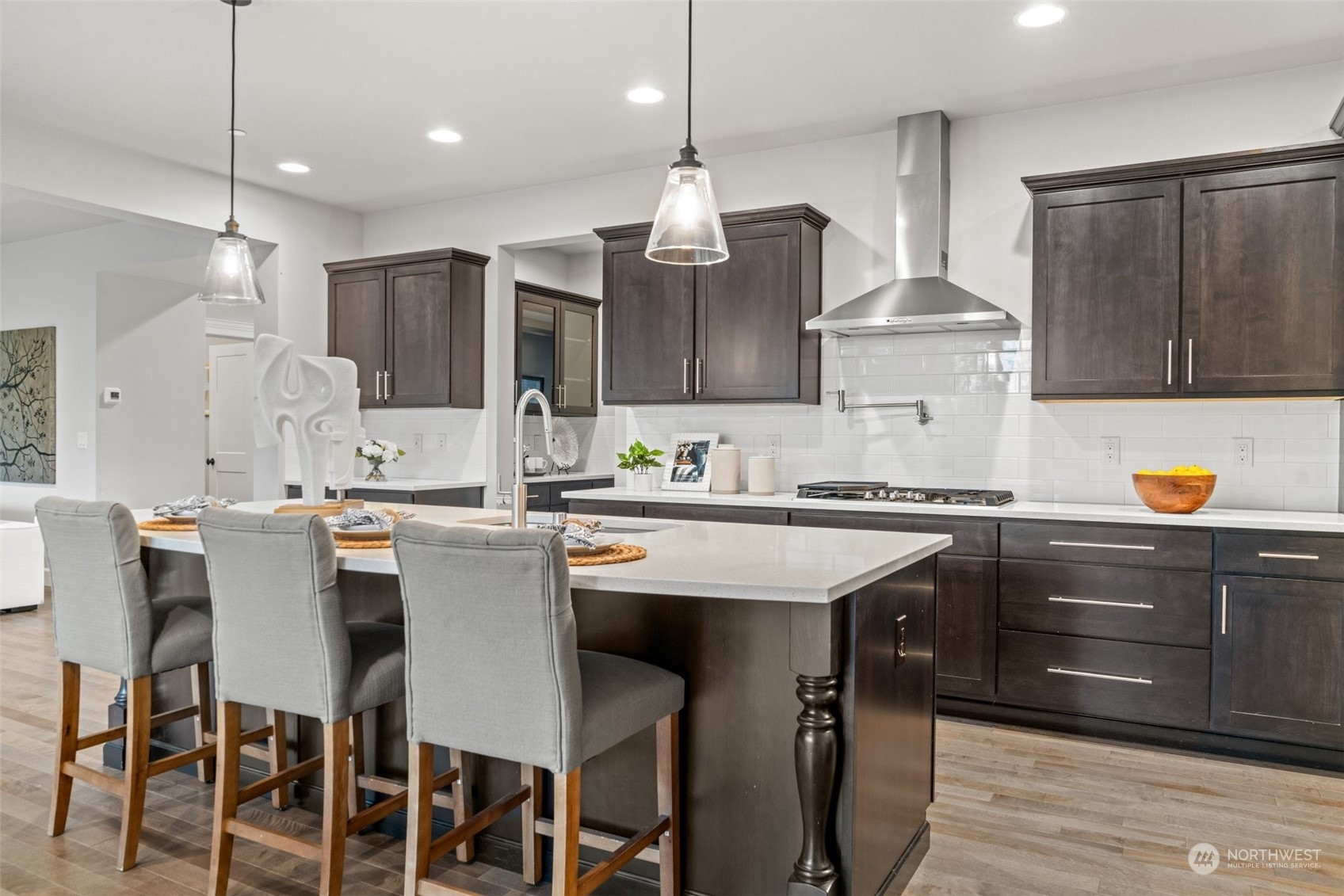24213 1st Avenue Southeast Bothell, WA 98021 - Photo 12 of 32 a kitchen with stainless steel appliances kitchen island granite countertop a table chairs sink and cabinets