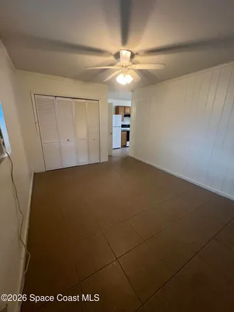 an empty room with a ceiling fan and a window