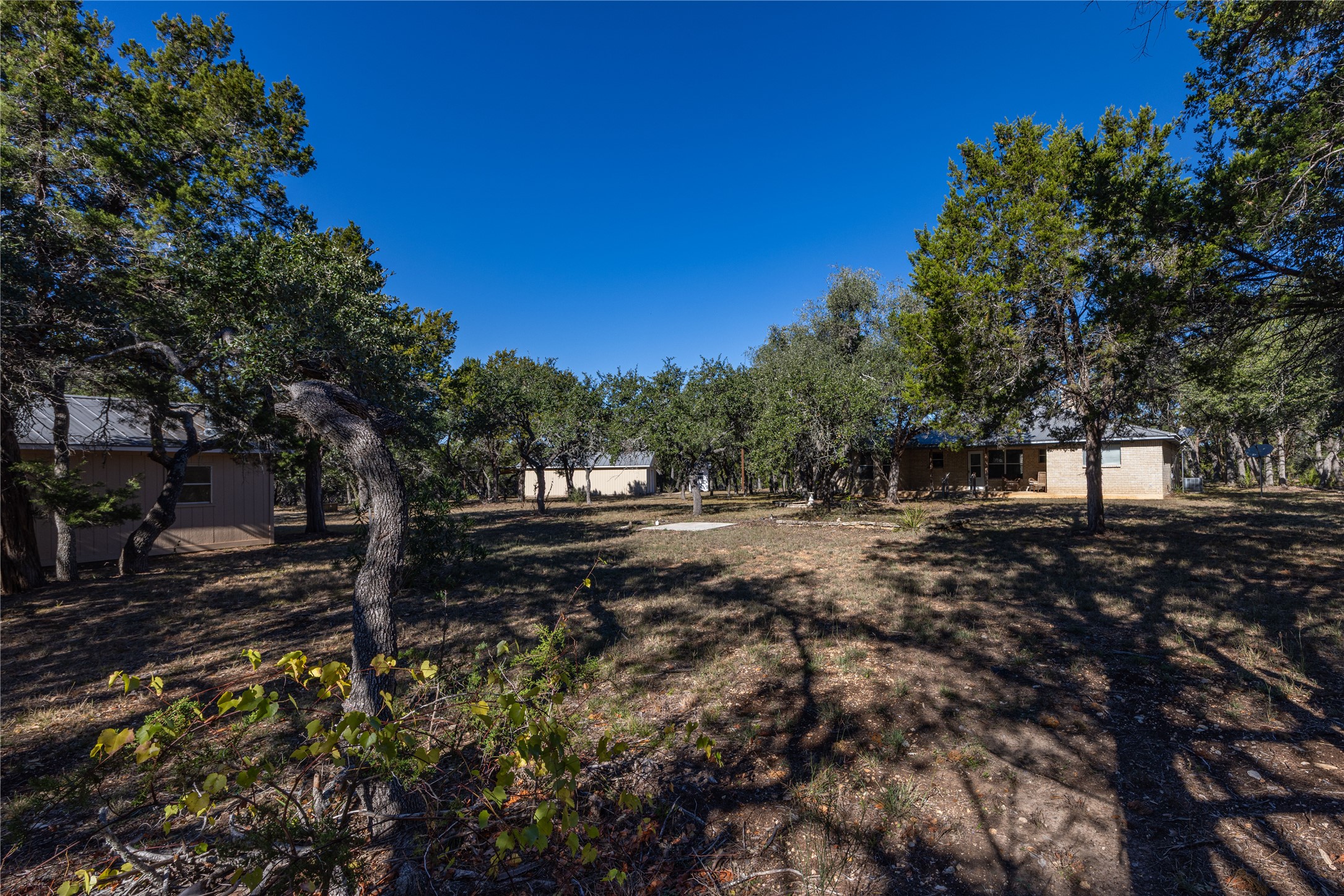 2501 Fischer Store Road Wimberley, TX 78676 - Photo 23 of 23 Expansive property featuring multiple detached structures, mature trees, and natural landscaping