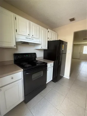 a kitchen with a refrigerator and cabinets