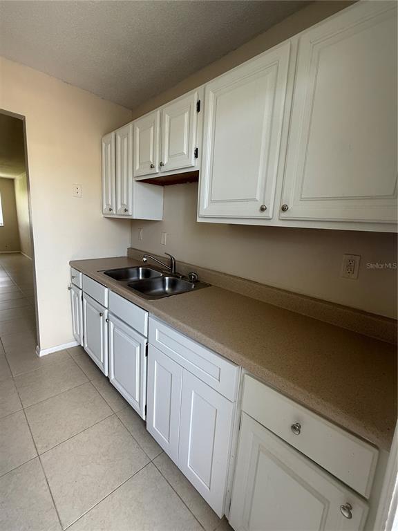2744 Botts Landing Road, Unit 702 DeLand, FL 32720 - Photo 4 of 12 a kitchen with granite countertop white cabinets and stainless steel appliances