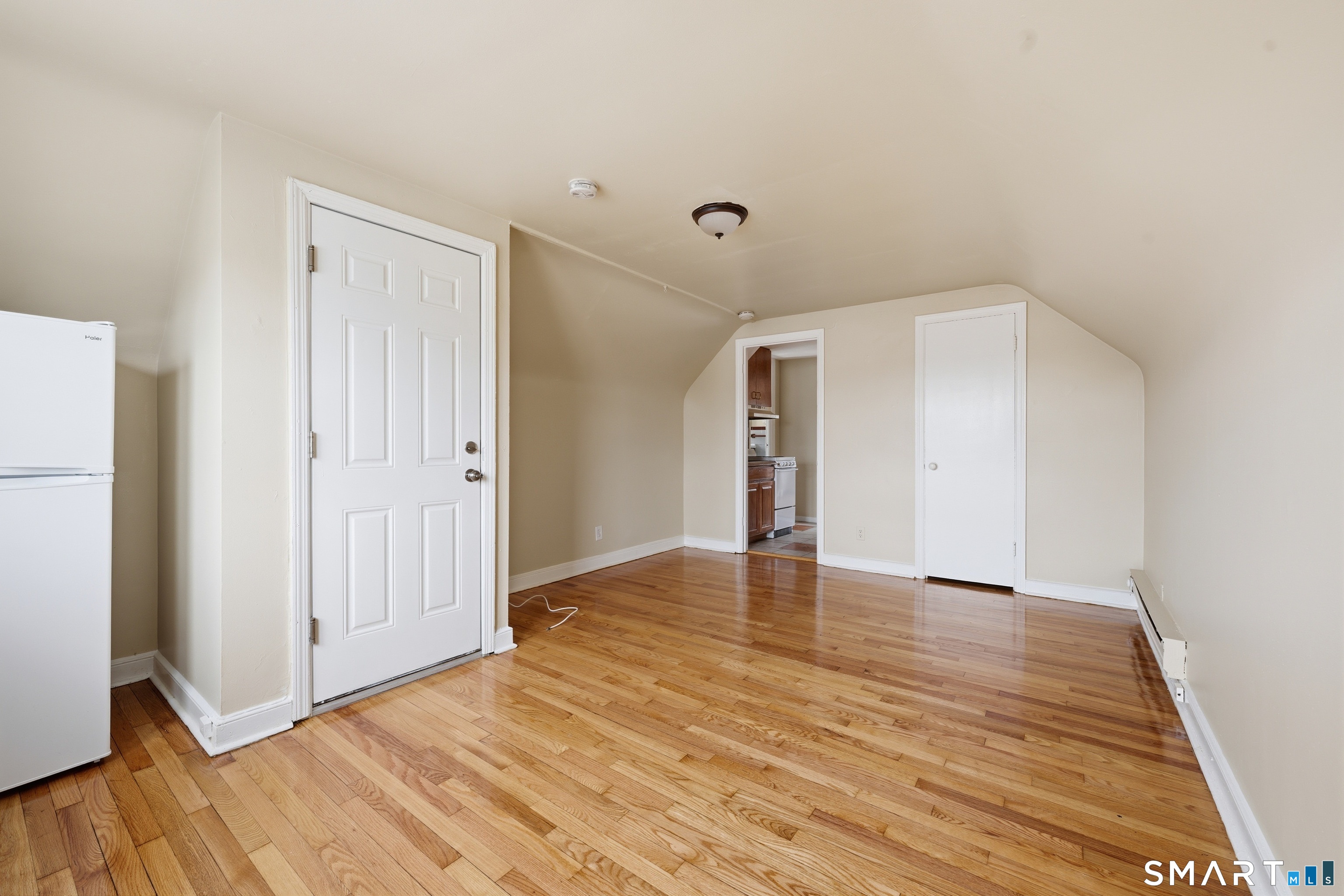 976 Capitol Avenue, Unit 3 Bridgeport, CT 06606 - Photo 3 of 12 a view of an empty room with wooden floor and a window