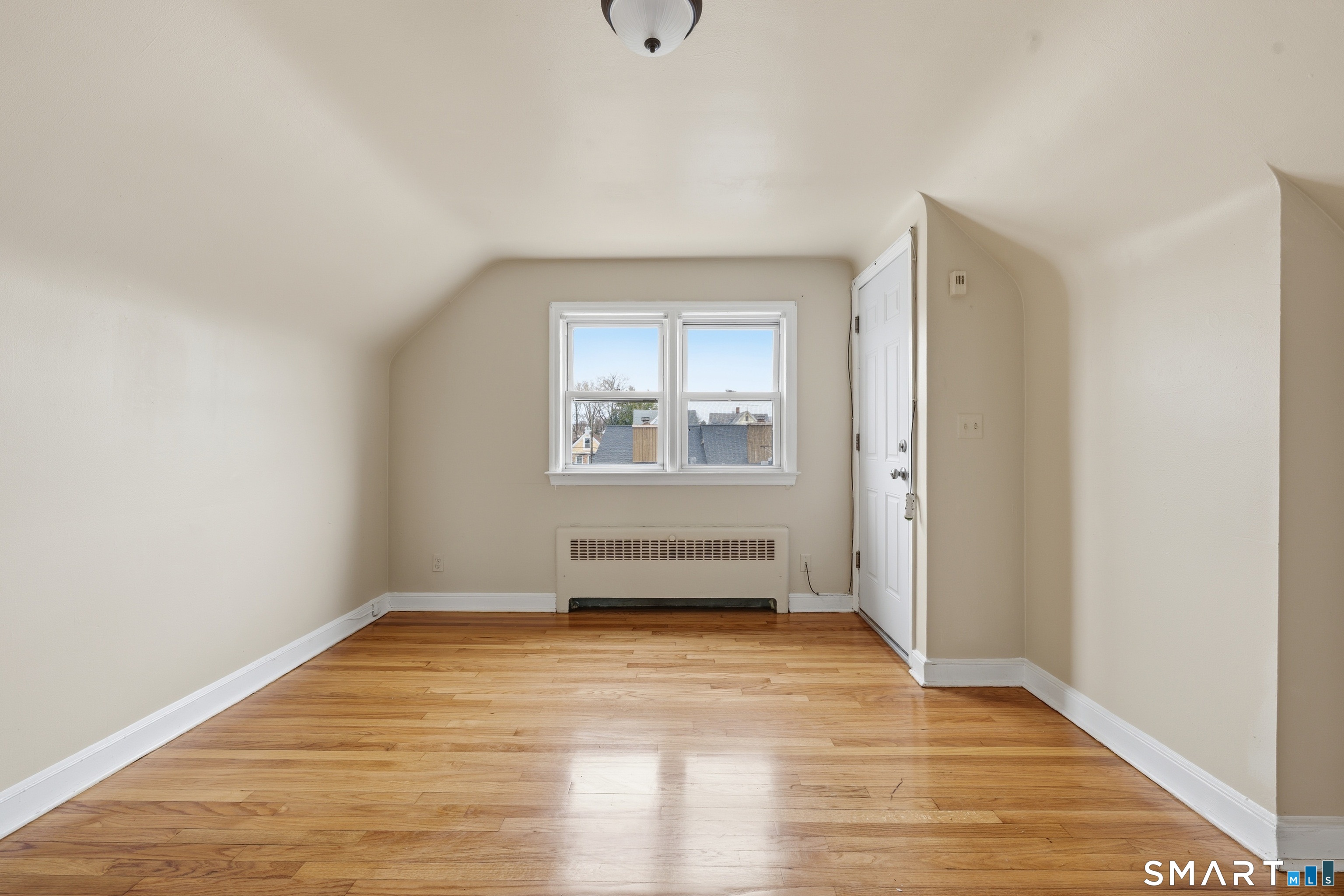 976 Capitol Avenue, Unit 3 Bridgeport, CT 06606 - Photo 7 of 12 an empty room with wooden floor and windows