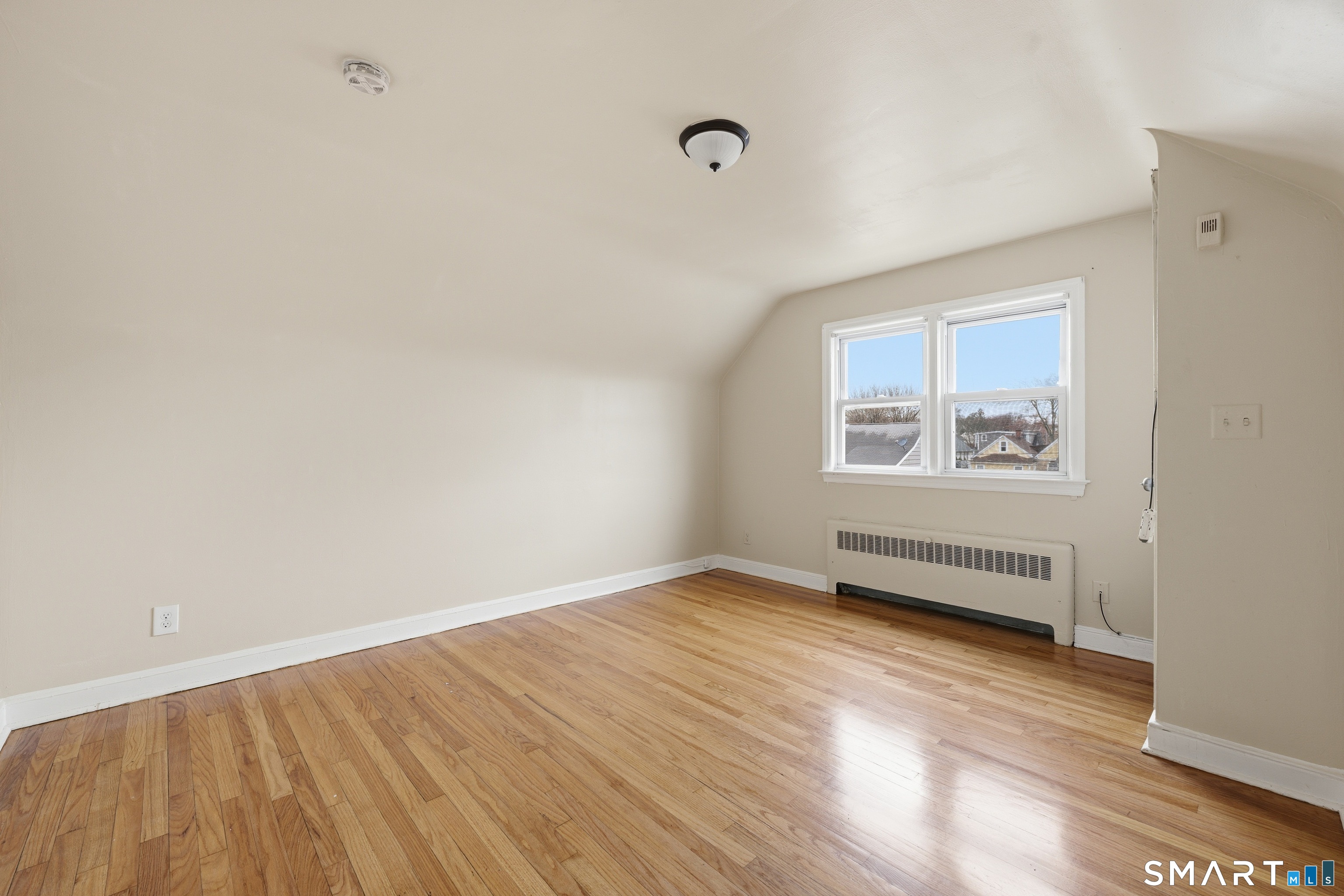 976 Capitol Avenue, Unit 3 Bridgeport, CT 06606 - Photo 9 of 12 an empty room with wooden floor and windows