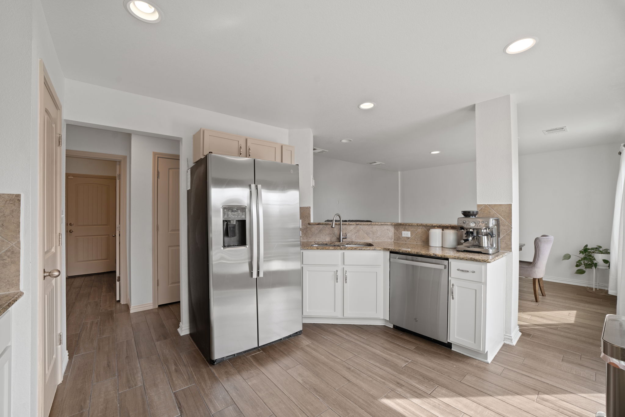 13109 Pealing Way Manor, TX 78653 - Photo 9 of 32 Kitchen featuring stainless steel appliances, light wood-style flooring, light stone counters, recessed lighting, and backsplash