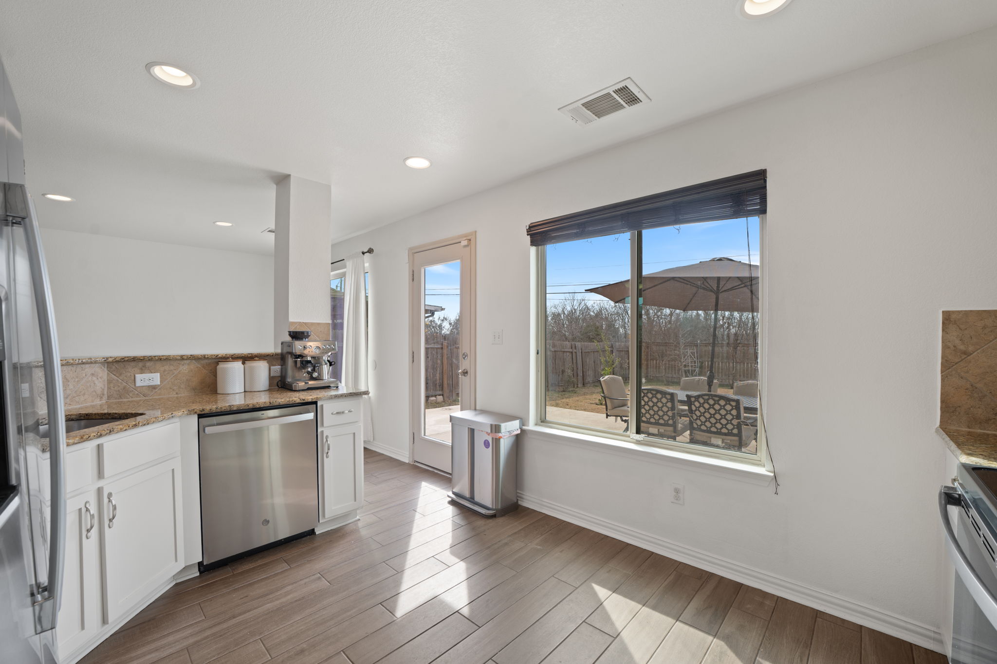 13109 Pealing Way Manor, TX 78653 - Photo 10 of 32 Kitchen featuring white cabinetry, light stone counters, stainless steel appliances, wood tiled floors, and recessed lighting