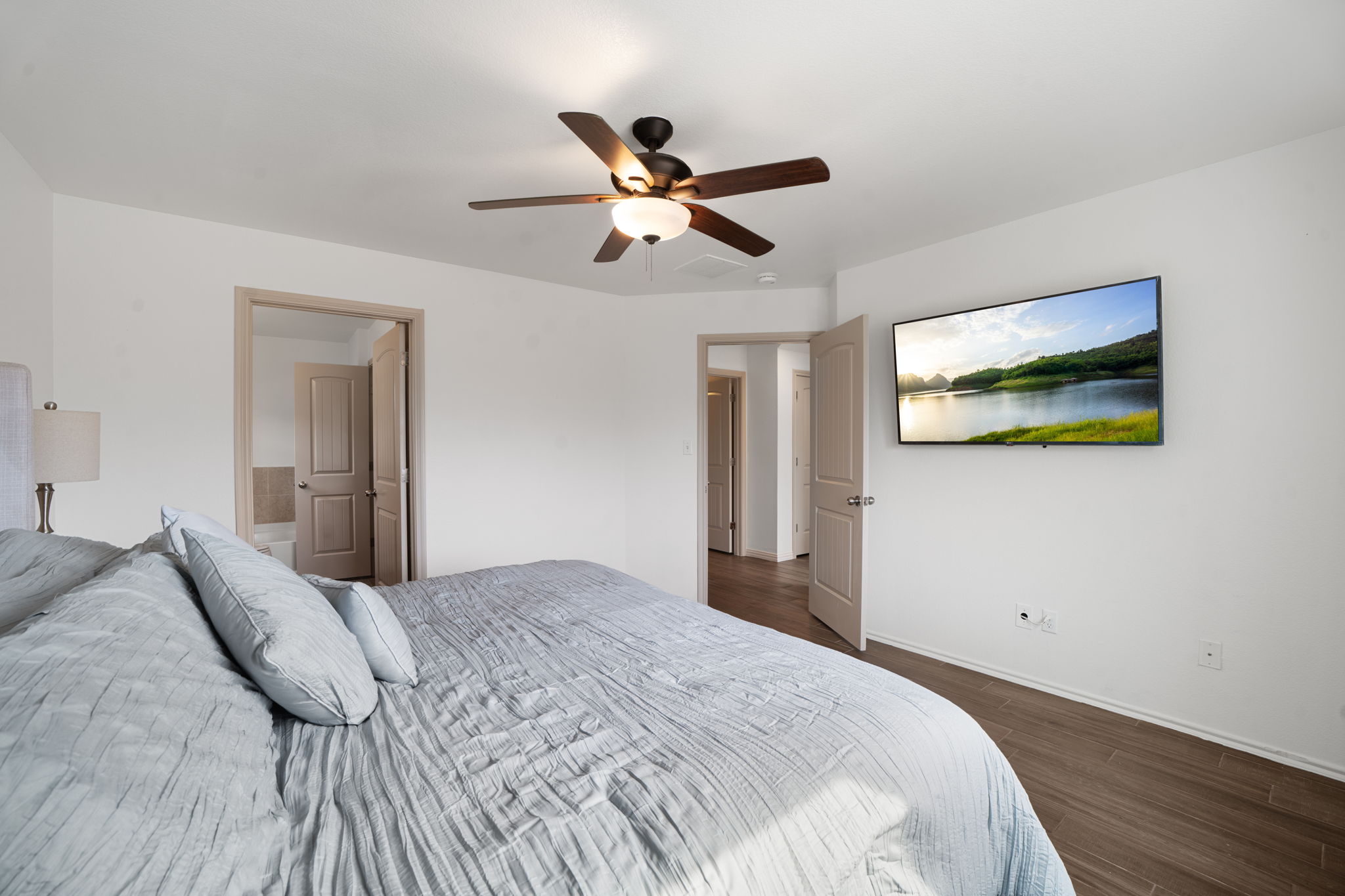 13109 Pealing Way Manor, TX 78653 - Photo 16 of 32 Bedroom featuring dark wood-style floors, ceiling fan, and ensuite bath