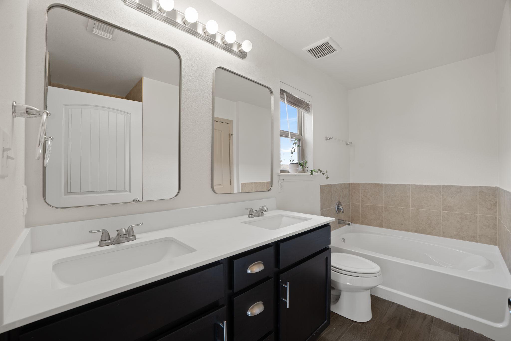 13109 Pealing Way Manor, TX 78653 - Photo 17 of 32 Full bathroom with a bath, double vanity, and dark wood-type flooring