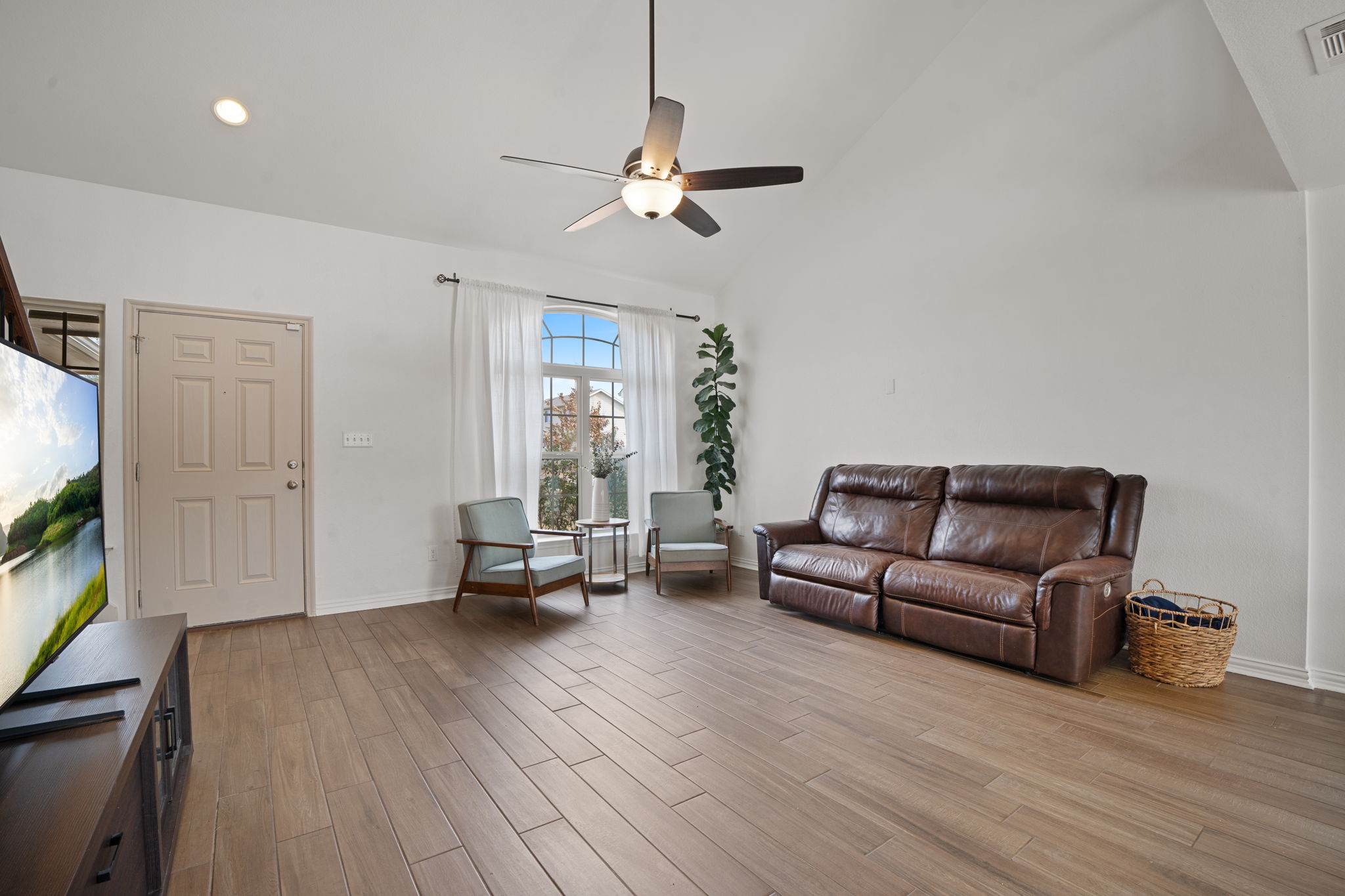 13109 Pealing Way Manor, TX 78653 - Photo 4 of 32 Living area with light wood-style flooring, vaulted ceiling, and ceiling fan
