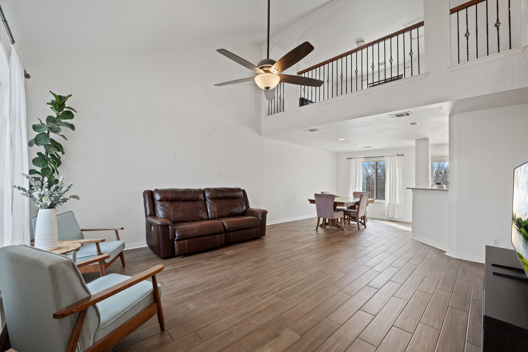 13109 Pealing Way Manor, TX 78653 - Photo 6 of 32 Living area featuring wood finished floors, a high ceiling, and ceiling fan