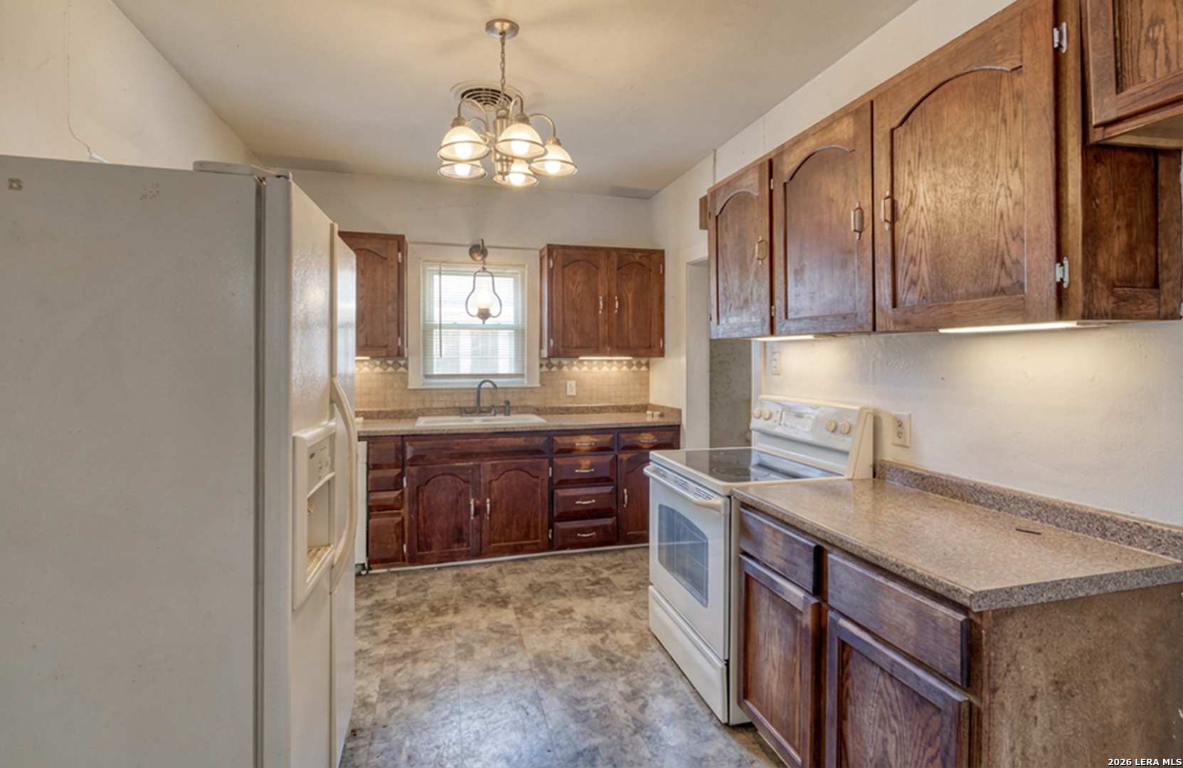 227 West Mueller Street Uvalde, TX 78801 - Photo 15 of 27 a kitchen with kitchen island granite countertop a sink stove and refrigerator