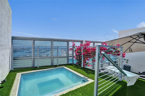 an aerial view of residential houses with outdoor space and ocean view