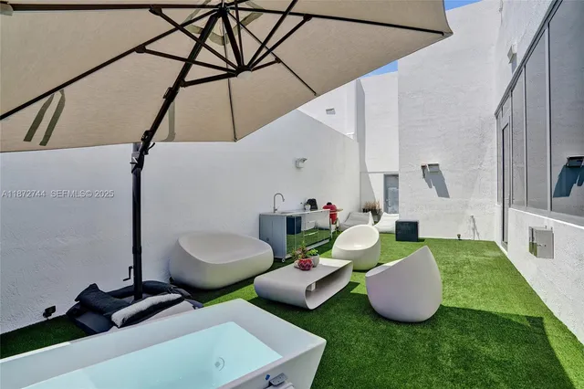 a living room with stainless steel appliances kitchen island granite countertop a sink and white cabinets next to a window