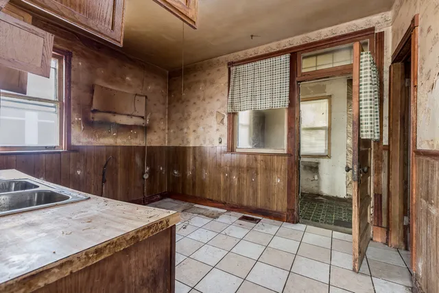 an empty room with window and wooden door