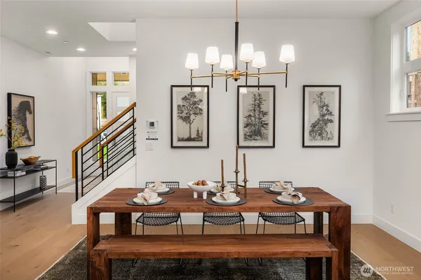 a dining room with wooden floor a chandelier a wooden table and chairs