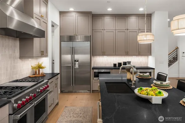 a kitchen with stainless steel appliances kitchen island granite countertop a stove and a refrigerator