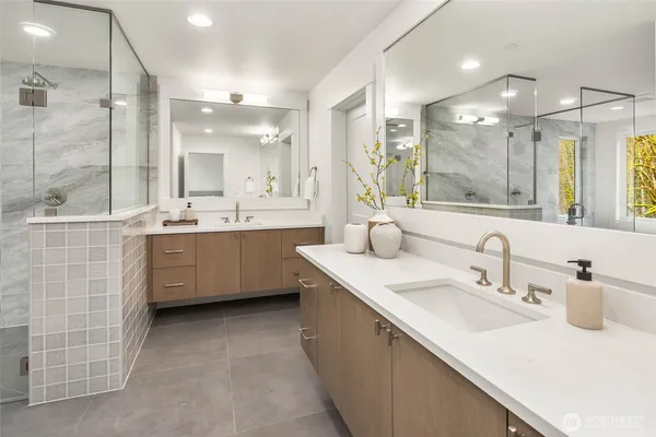 a bathroom with a double vanity sink mirror and shower