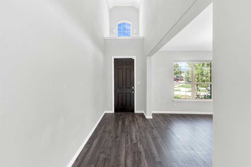 7640 Rhyner Way Fort Worth, TX 76137 - Photo 4 of 40 Entryway featuring wood-finish flooring, a dark-paneled door, and a transom window