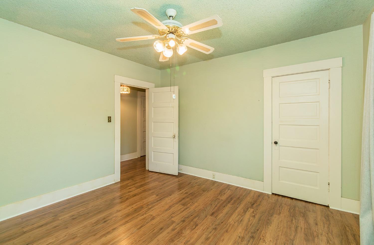 37991 Pound Road Dinuba, CA 93618 - Photo 22 of 32 an empty room with wooden floor and a ceiling fan