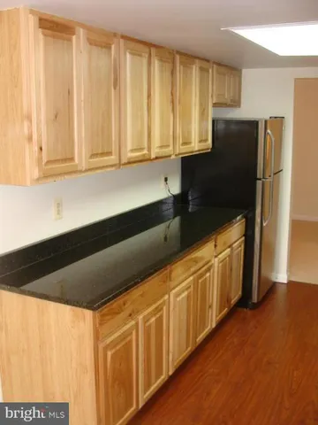 a kitchen with stainless steel appliances granite countertop white cabinets and a refrigerator