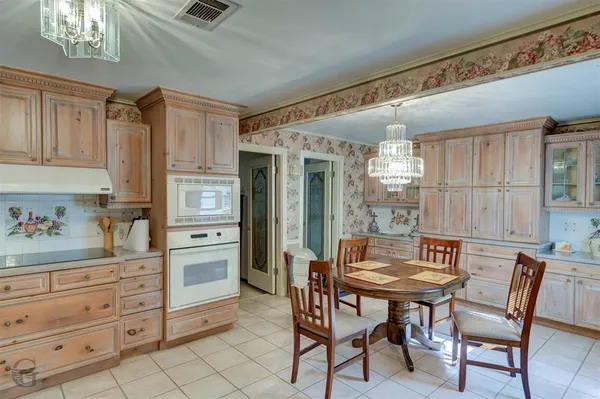 a kitchen with granite countertop a table chairs stove and cabinets