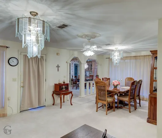 a view of a dining room with furniture and chandelier