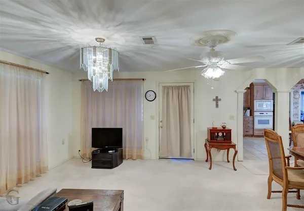 a view of a livingroom with furniture and chandelier fan