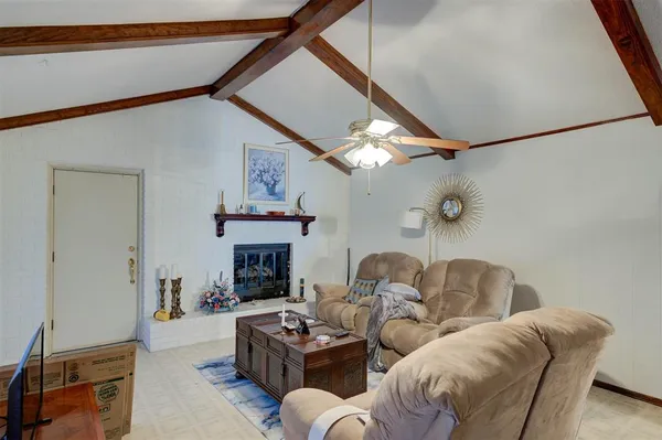 a living room with furniture a fireplace and a chandelier