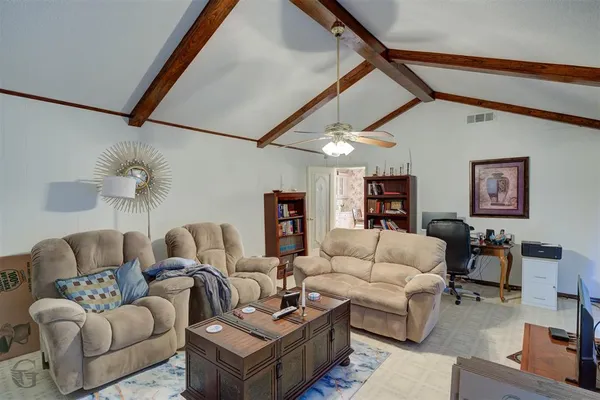 a living room with furniture and a ceiling fan