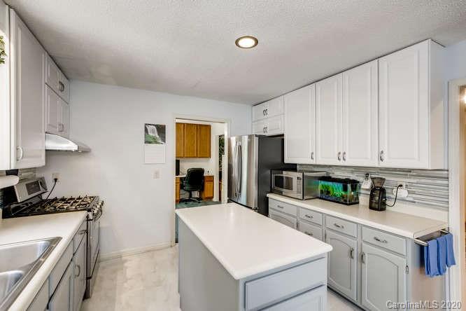 418 Park Ridge Road Albemarle, NC 28001 - Photo 10 of 28 a kitchen with stainless steel appliances white cabinets and sink