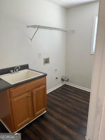 a utility room with cabinets and wooden floor