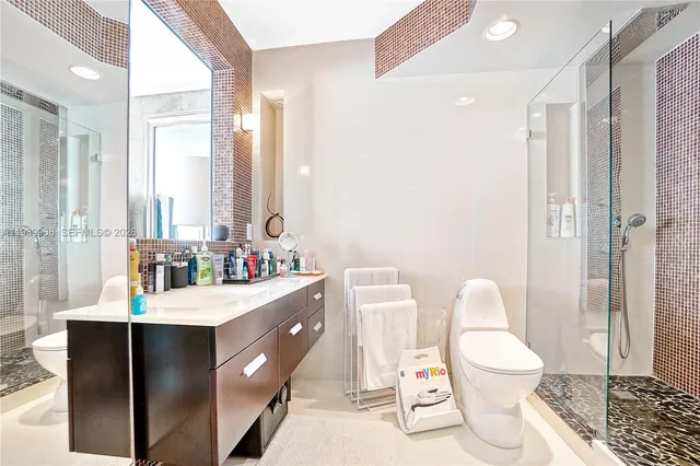 a bathroom with a double vanity sink toilet and shower