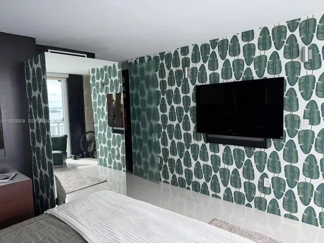 a living room with a flat screen tv and a wooden floor