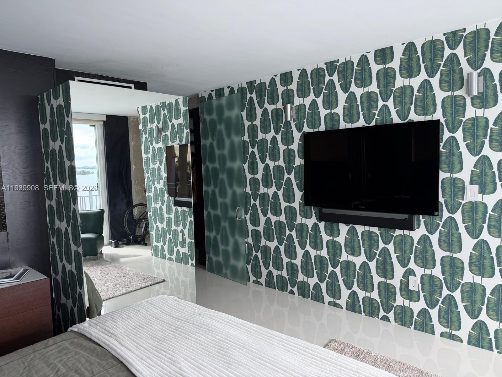 770 Northeast 69th Street, Unit 6F Miami, FL 33138 - Photo 14 of 47 a living room with a flat screen tv and a wooden floor