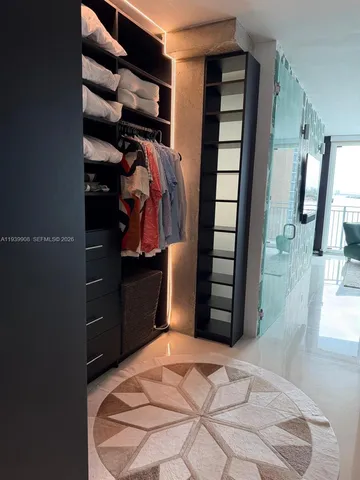 a view of walk in closet with clothes and shoes