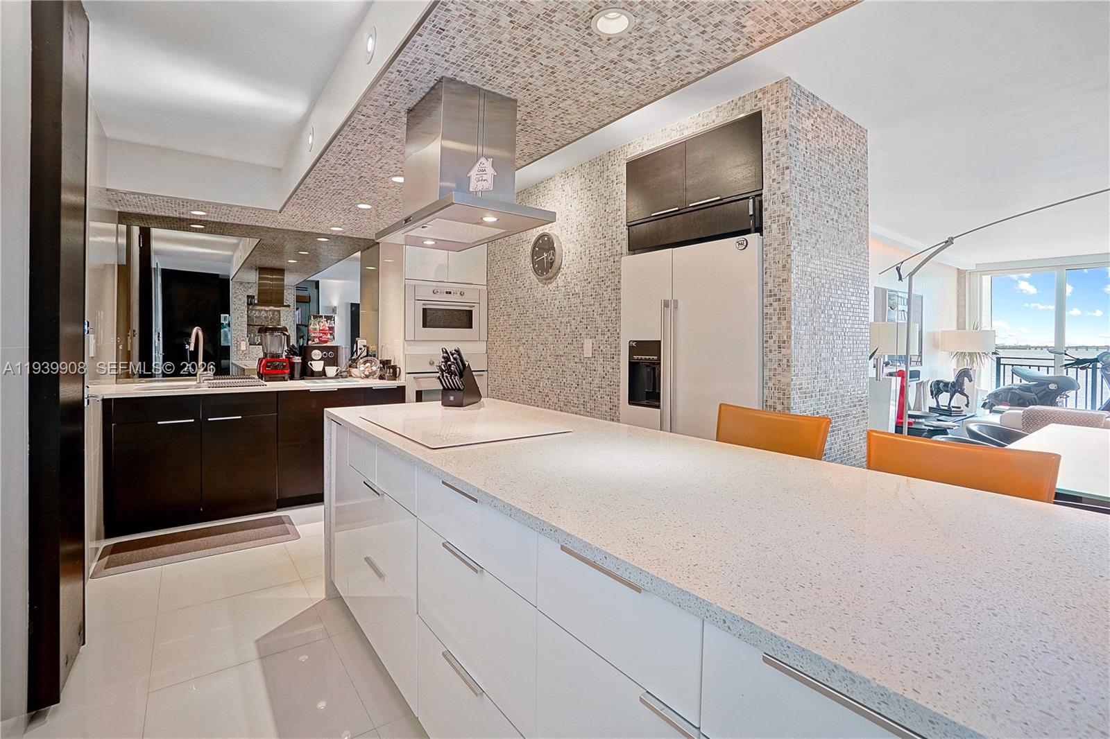 770 Northeast 69th Street, Unit 6F Miami, FL 33138 - Photo 4 of 47 a large white kitchen with a large counter top space and stainless steel appliances