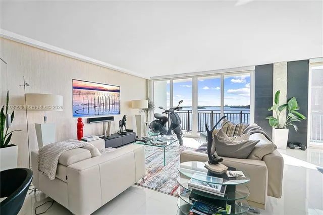 a living room with furniture a flat screen tv and a floor to ceiling window