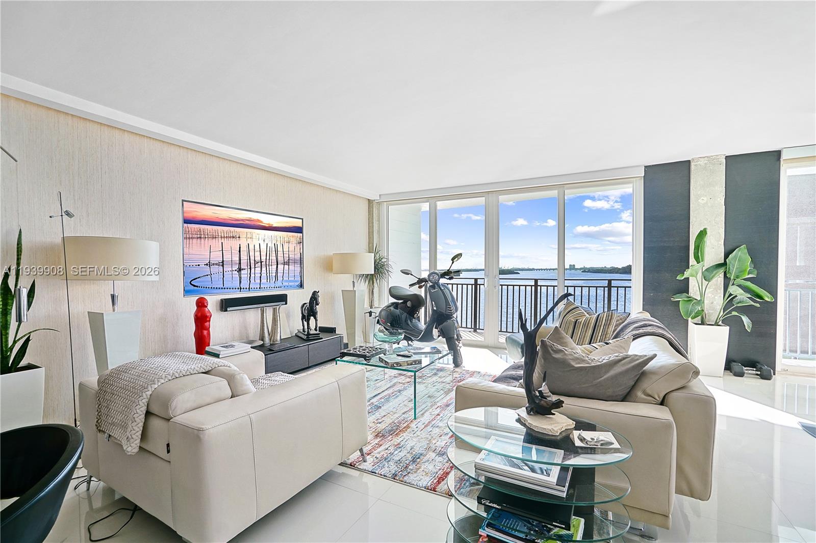 770 Northeast 69th Street, Unit 6F Miami, FL 33138 - Photo 9 of 47 a living room with furniture a flat screen tv and a floor to ceiling window