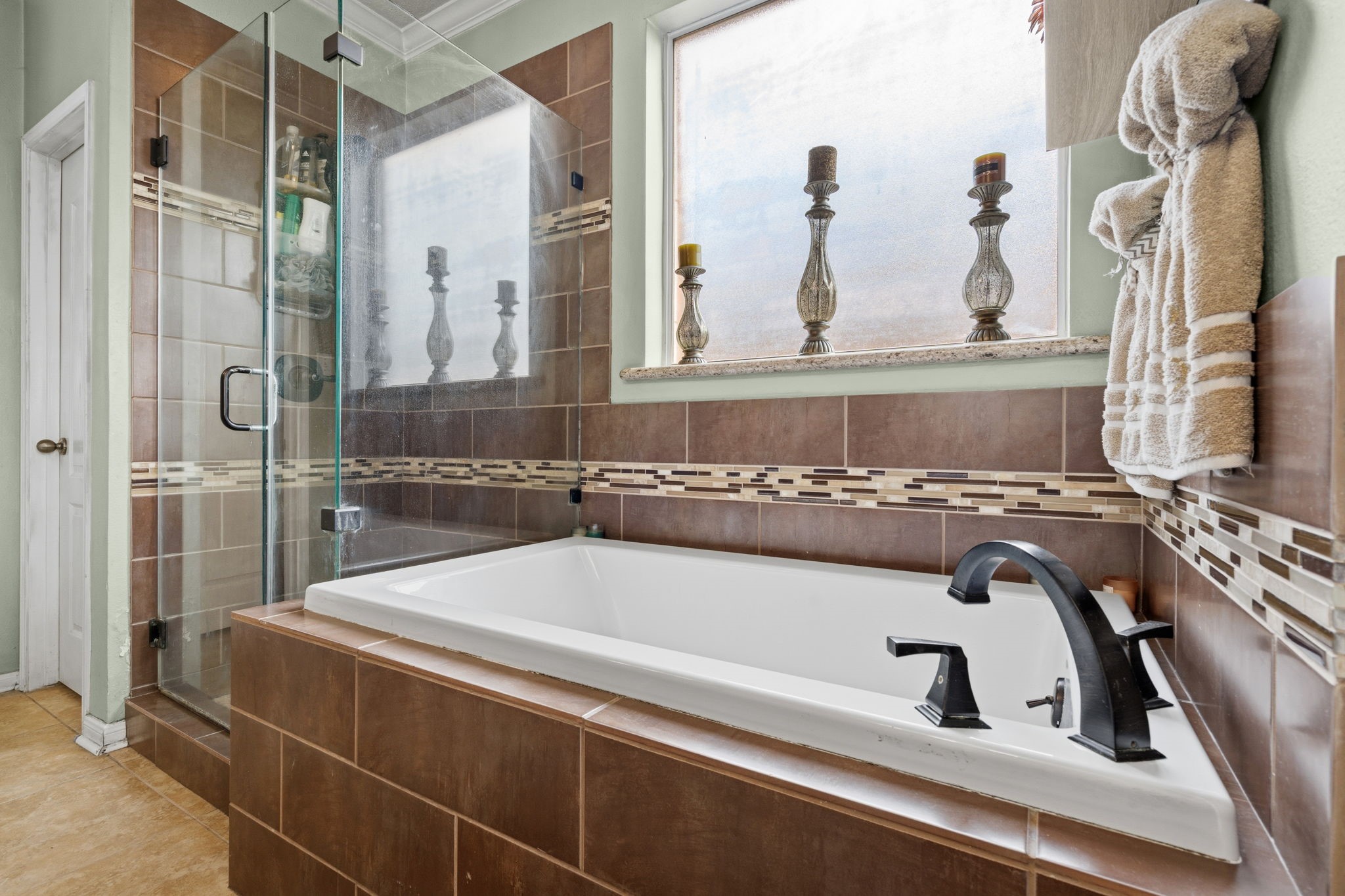 1319 Collier Point Lane Fresno, TX 77545 - Photo 19 of 33 A beautiful soaking tub invites you to unwind after a long day, surrounded by elegant tilework and calming design elements.