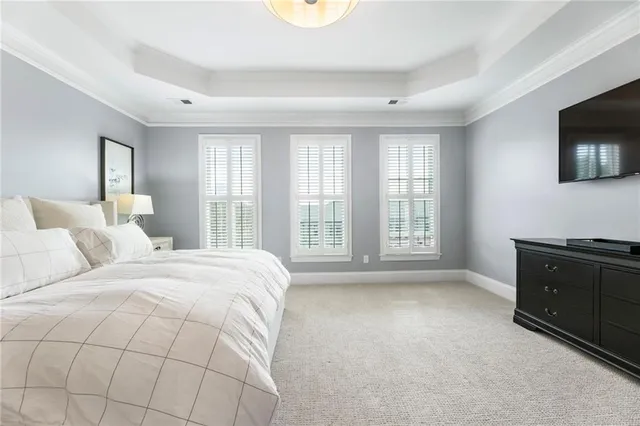 a spacious bedroom with a bed and a television