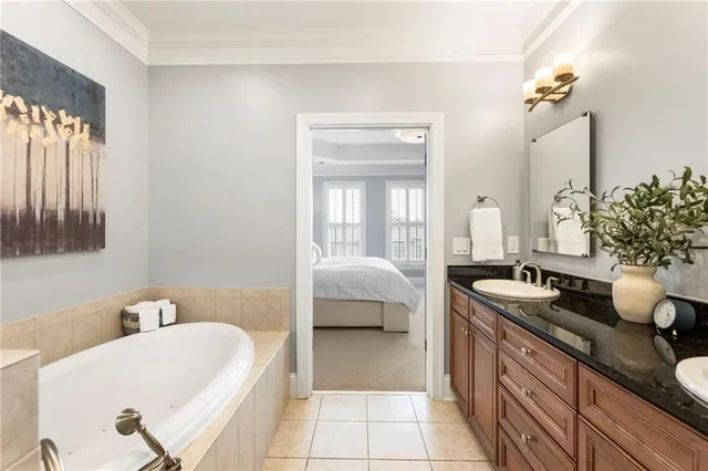 a spacious bathroom with a tub sink and mirror