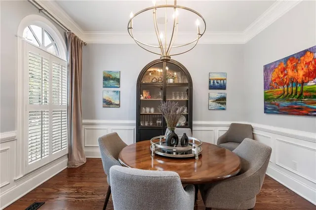 a dining room with furniture a large window and wooden floor