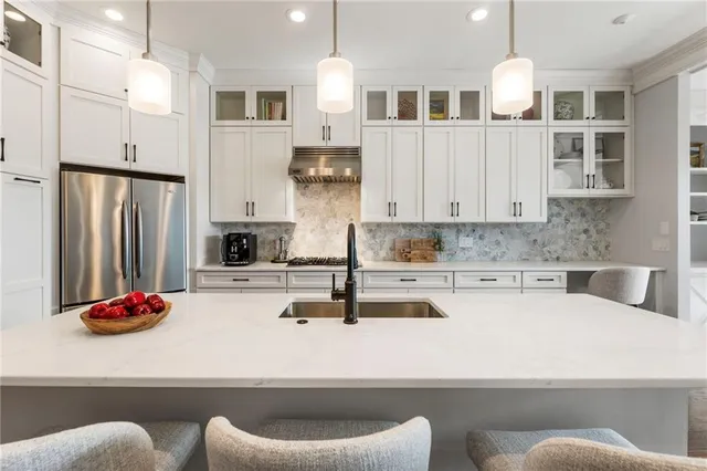 a kitchen with kitchen island granite countertop a white cabinets and stainless steel appliances