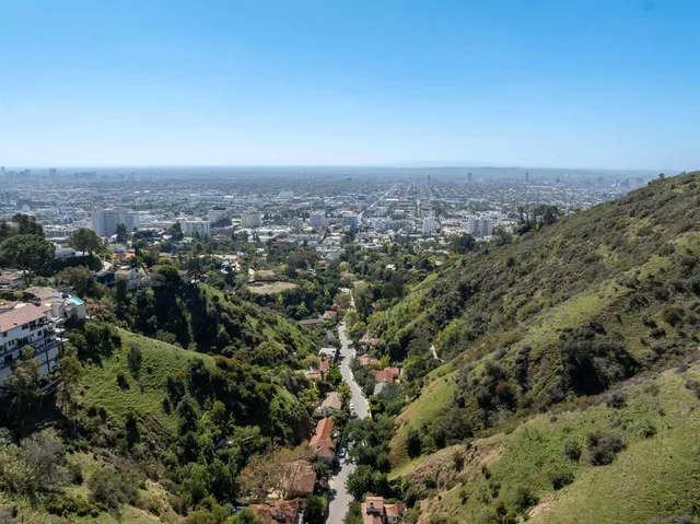 an aerial view of house with yard and mountain view in back